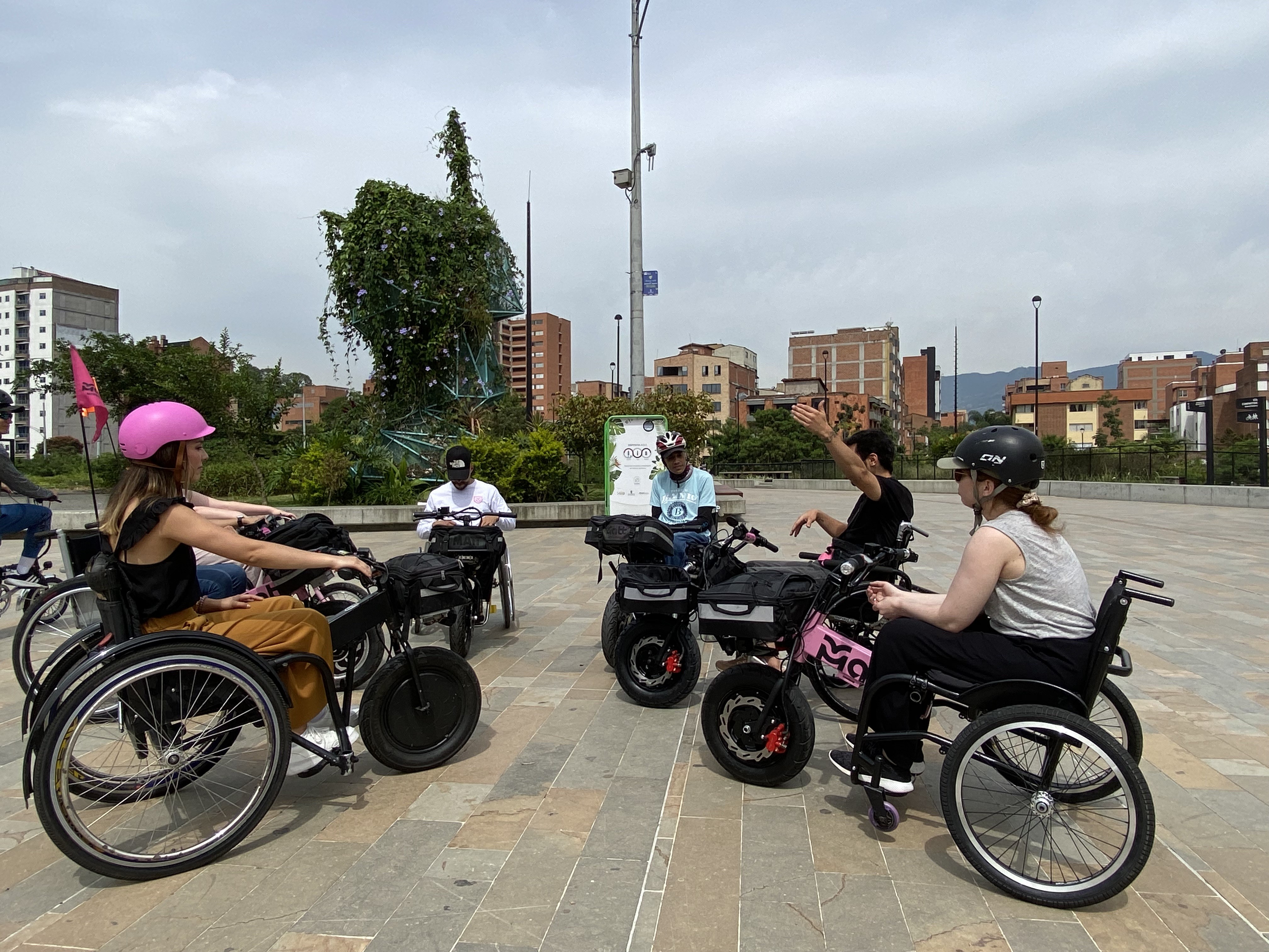 A group of people navigate a city in electric wheelchairs