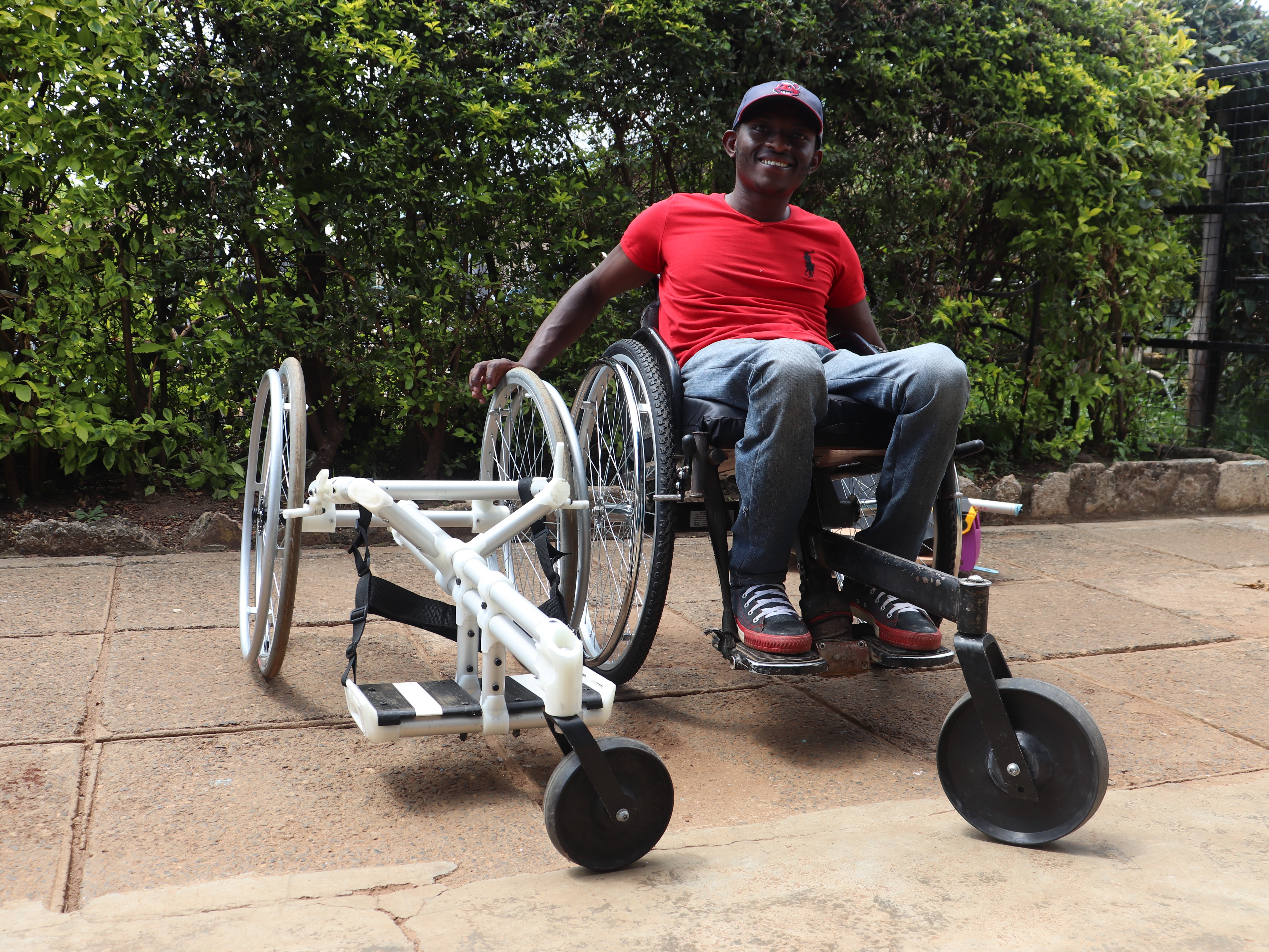 A man poses next to a new model of his wheelchair
